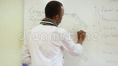 黑人教师在白板上写字，向学生解释材料